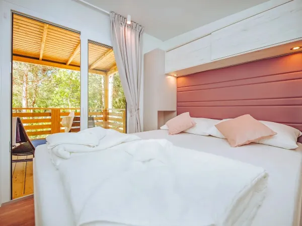 Camera del Roan Comfort Plus Lounge con letto matrimoniale.