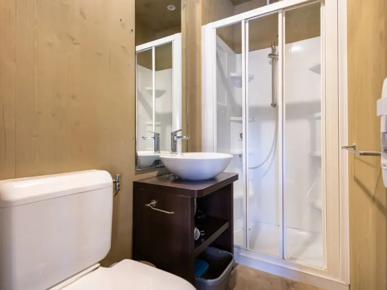Il bagno del Roan Lodgetent Premium è dotato di cabina doccia di lusso, WC e lavandino.