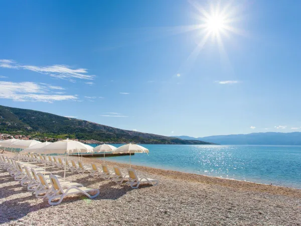 La spiaggia di ciottoli del campeggio Roan Baška Camping Resort.