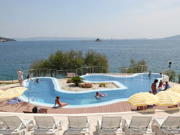 Piscina con lettini e ombrelloni al campeggio Roan Amadria Park Trogir.