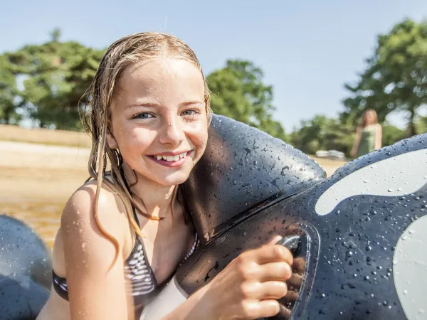 Ragazza con giochi gonfiabili nel lago naturale del campeggio Roan De Schatberg.