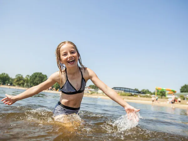 Ragazza nuota nella piscina naturale del Roan Luxury Camping De Schatberg.