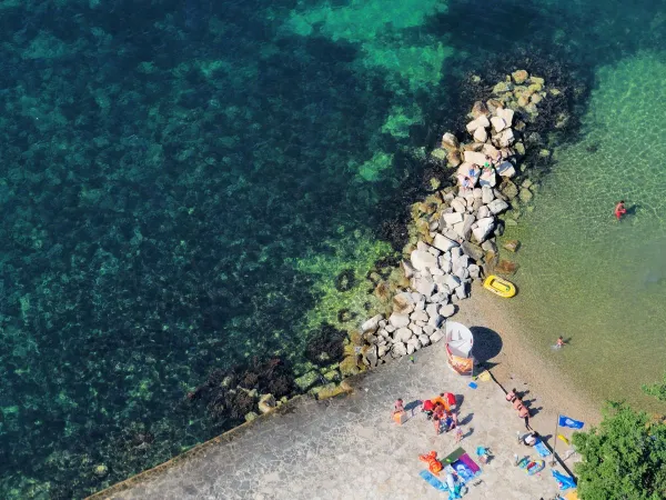 Acqua limpida e piattaforma per prendere il sole al Roan camping Valkanela.