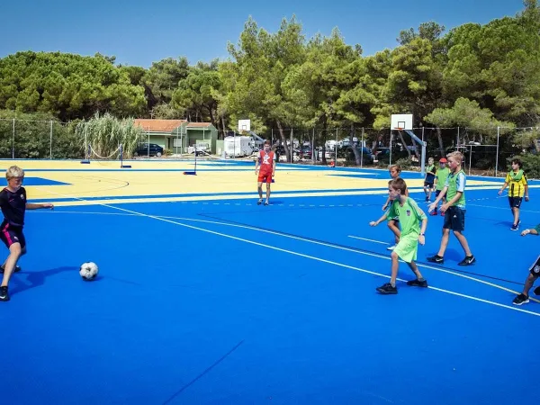 Giocare a calcio sul campo polisportivo del campeggio Roan di Zaton Holiday Resort.