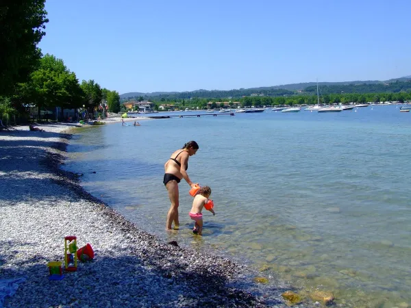 Madre con bambino nel lago del Roan campeggio La Rocca Manerba.