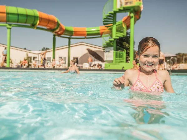 La piscina all'aperto con scivolo del Roan camping De Schatberg.