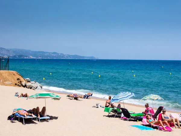 Persone che si divertono in riva al mare al Roan Camping El Pinar.