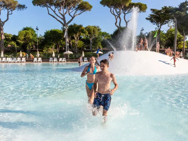 I bambini corrono nella piscina della laguna del Roan camping hu Park Albatros village.