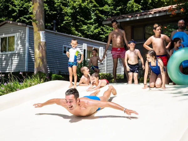 Ragazzo che scivola al campeggio Roan hu I Pini village.