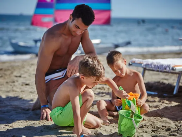 Bambini che si divertono in spiaggia al Roan camping Mediterraneo.
