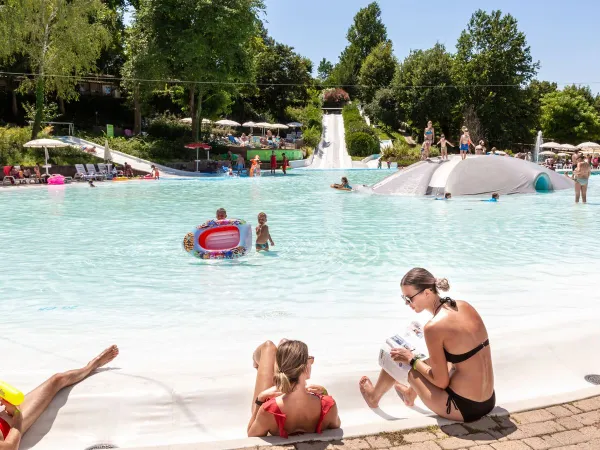 Genitori e bambini si godono la piscina lagunare del Roan Camping Altomincio.