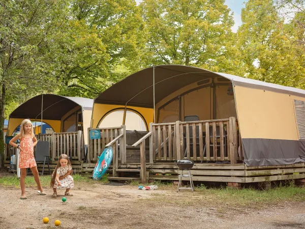 I bambini giocano davanti all'Holiday Lodgetent del campeggio Roan La Rocca Manerba.