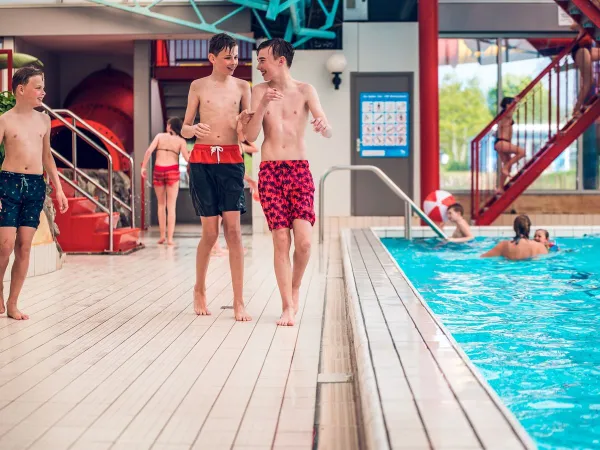 Giovani che giocano nella piscina coperta del Roan camping Ackersate.