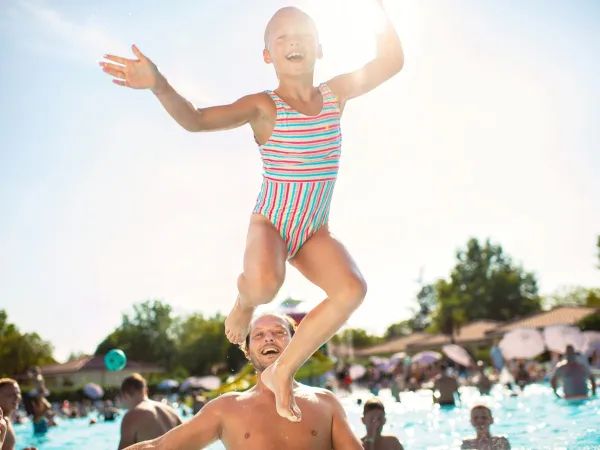 Bambino che salta in piscina.