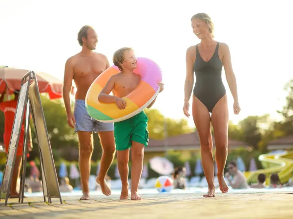 Padre, madre e figlio in piscina al campeggio Roan.