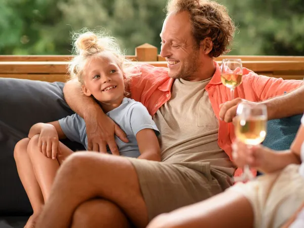 Famiglia che si rilassa sul divano del Roan Camping Butterfly.