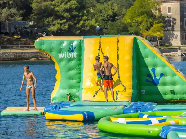 Divertimento nel parco giochi in mare del Roan camping Lanterna.