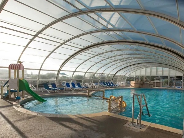 Piscina coperta con scivolo al campeggio Roan Le Domaine de Beaulieu.