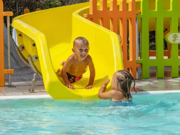 Bambino scivola giù per il divertente scivolo del campeggio Roan Rubicone.