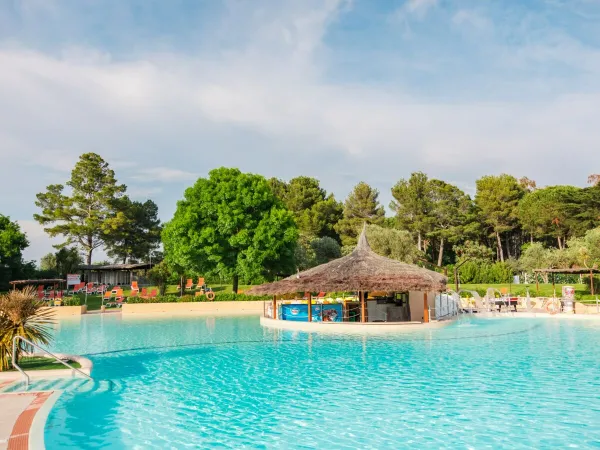 Piscina con tenda tiki al campeggio Roan Le Capanne.