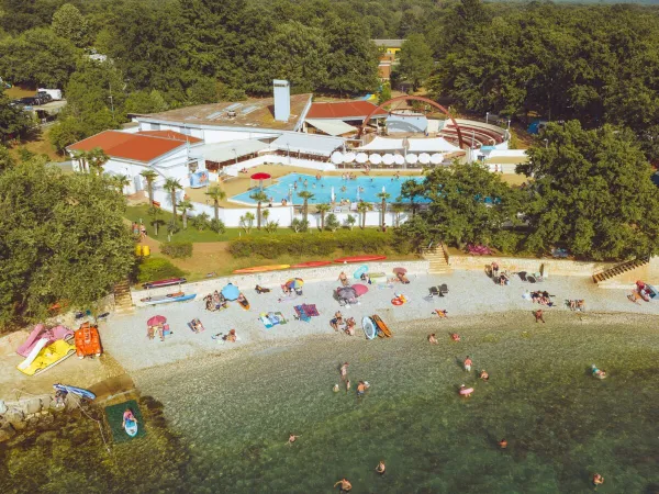 Panoramica della spiaggia di ghiaia e della piscina del campeggio Roan di Bijela Uvala.