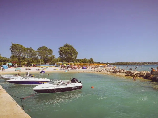 Spiaggia con molo e barche al campeggio Roan Bi Village.