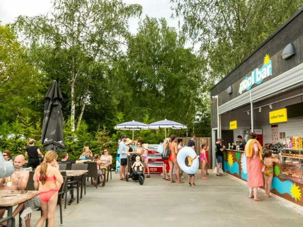 Le persone prendono qualcosa di gustoso al bar della piscina del Roan camping Birkelt village.