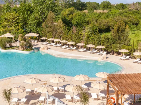 Piscina con lettini e ombrelloni al Roan camping La Chapelle.