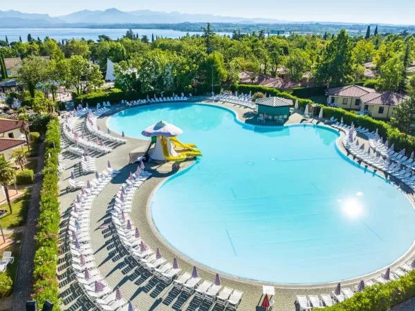 Piscina con scivoli e lettini al Roan camping Bella Italia.