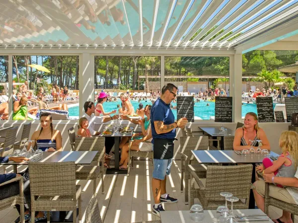 Una terrazza completa a bordo piscina al campeggio Roan Le Castellas.