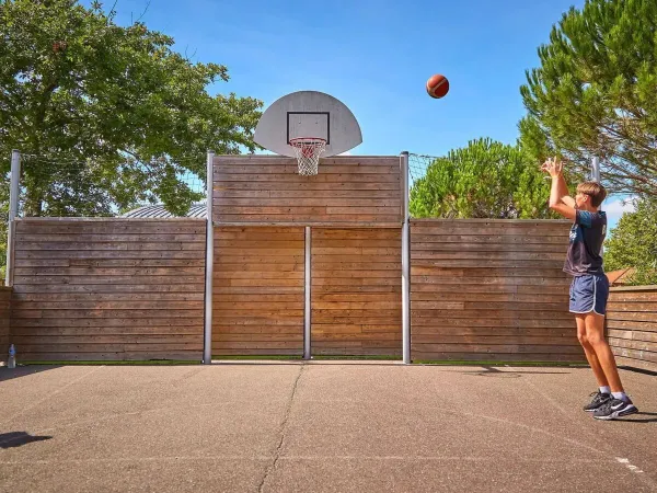 Ragazzo che gioca a basket al campeggio Roan di Mayotte Vacances.