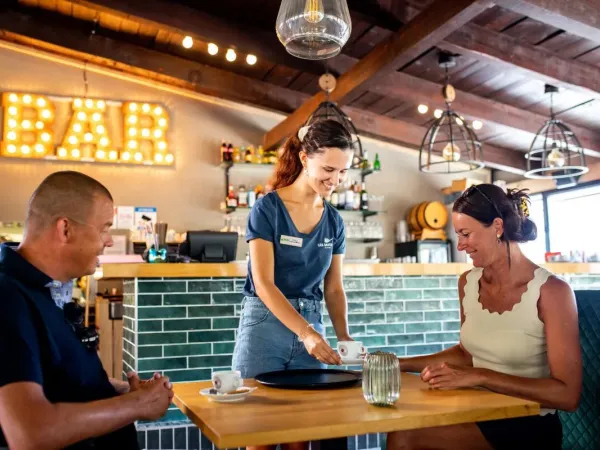 Le persone si godono un drink al bar del campeggio Roan Domaine de la Noguière.