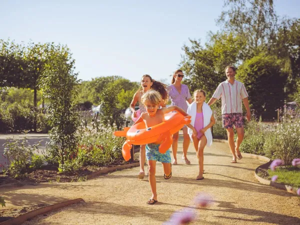 Famiglia che si dirige verso la piscina del campeggio Roan Le Domaine du Clarys.