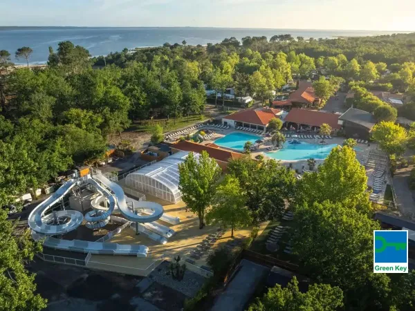 Panoramica della piscina con scivolo e del mare in lontananza al Roan camping Mayotte Vacances.