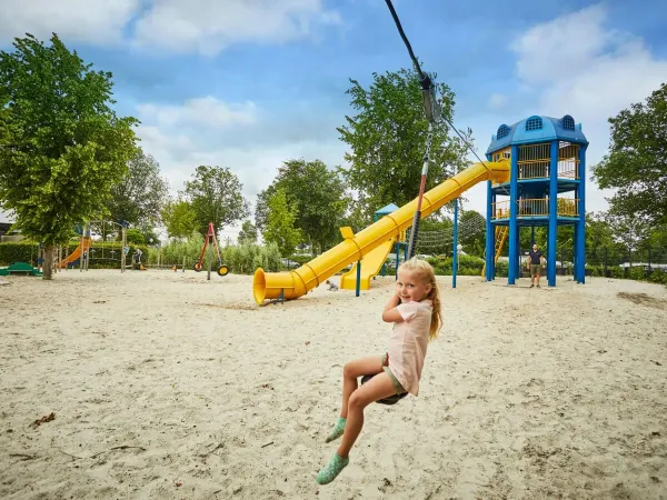 Ragazza sulla funivia nel grande parco giochi del campeggio Roan Terspegelt.