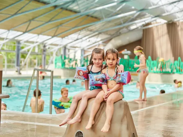 Due ragazze su una pietra nella piscina coperta del campeggio Roan Terspegelt.