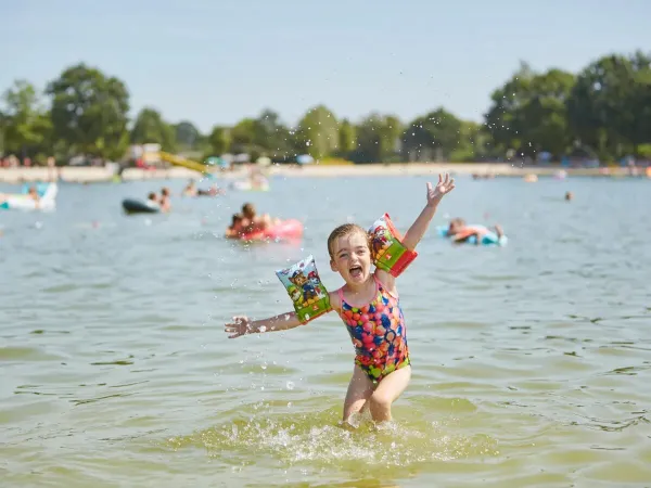 Ragazza felice nella piscina del campeggio Roan Terspegelt.