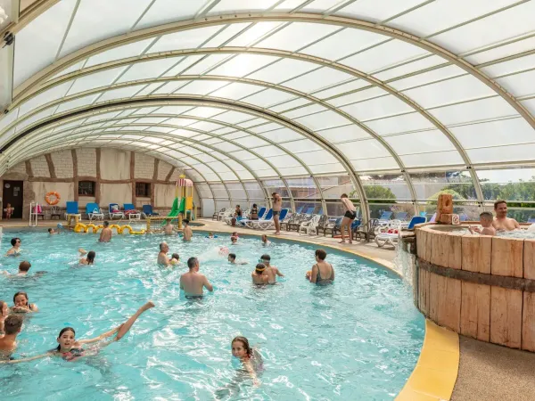 Piscina coperta con scivolo al campeggio Roan Le Domaine de Beaulieu.