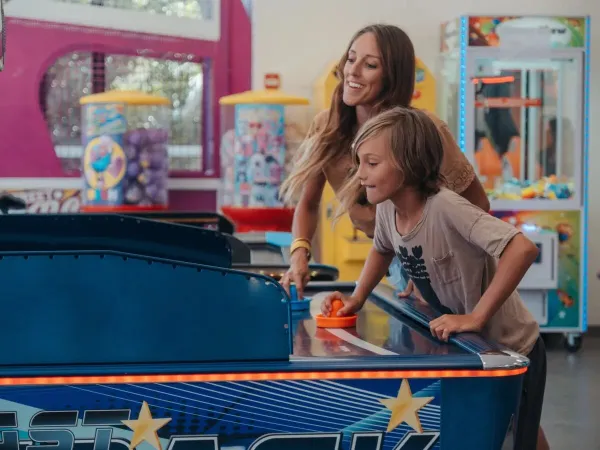 Madre e figlio alle slot machine del campeggio Roan Les Méditerranées Beach Garden.