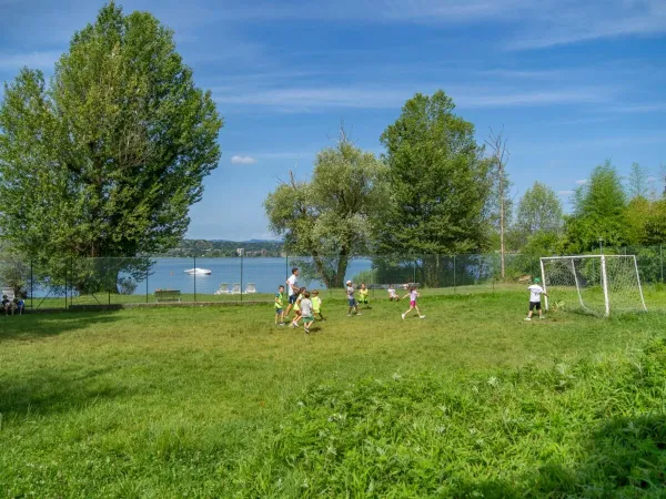 I bambini giocano a calcio sul campo del campeggio Roan Okay Lido.