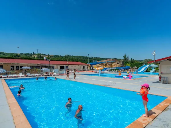 Le famiglie fanno un tuffo in piscina al Roan camping Chateau de Galaure.