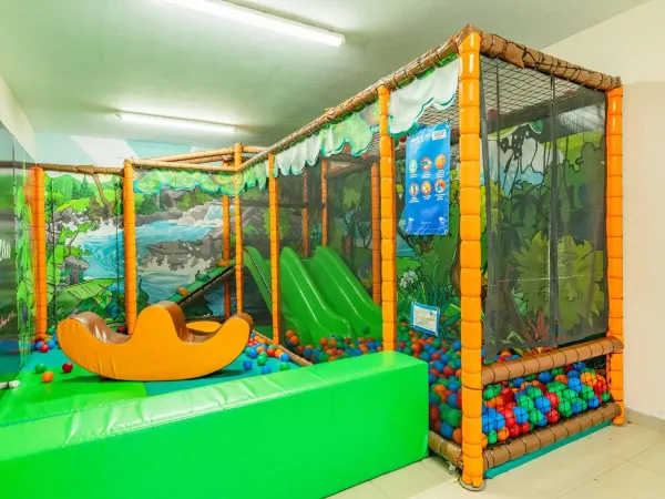 Area giochi interna per i più piccoli al Roan camping Domaine de Massereau.