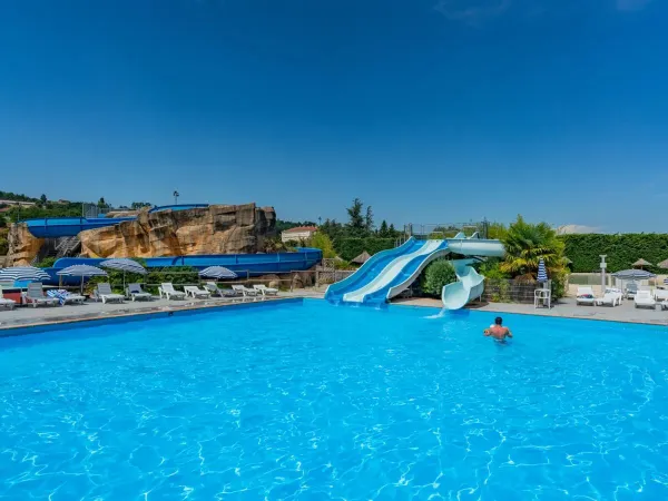 Le famiglie fanno un tuffo in piscina al Roan camping Chateau de Galaure.