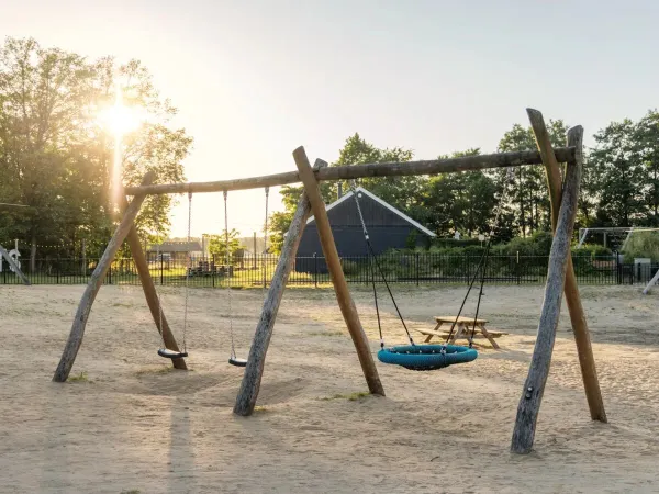 Il parco giochi di sabbia con altalene del Roan camping de Twee Bruggen.