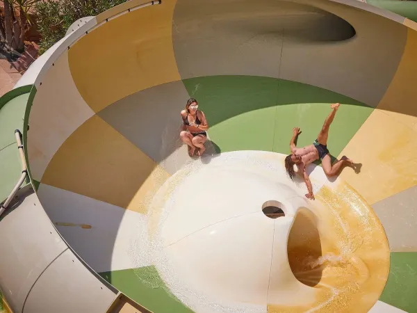 Due persone si divertono sullo scivolo tornado del campeggio Roan Le Petit Mousse.