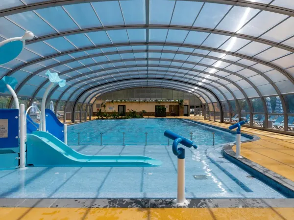 Piscina con scivolo per i più piccoli al campeggio Roan Le Lac des Vieilles Forges.