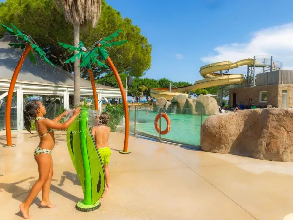 I bambini si divertono con gli spruzzatori d'acqua del campeggio Roan Arinella Bianca.