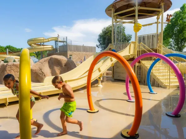 I bambini corrono tra gli irrigatori del campeggio Roan Arinella Bianca.