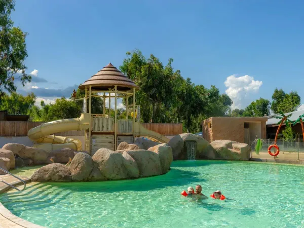 Padre e figli nuotano nella piscina del campeggio Roan Arinella Bianca.