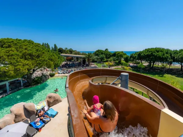 Madre e figlio scivolano sullo scivolo del campeggio Roan Arinella Bianca.